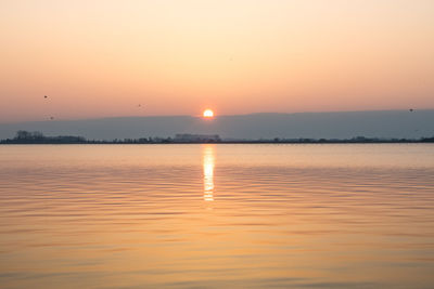 Scenic view of sea against orange sky