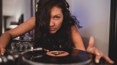 Close-up of fashionable young woman playing music at home