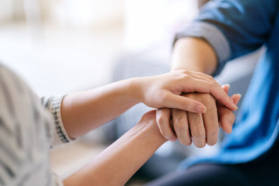 Midsection of couple holding hands