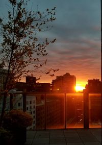 Silhouette buildings against sky at sunset