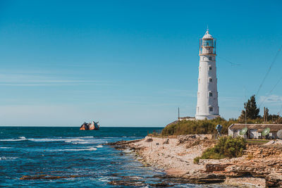 White lighthouse and sunken ship in the sea