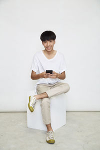 Portrait of smiling man holding mobile phone