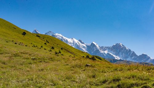 Scenic view of mountains against blue sky