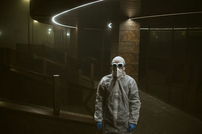 Man standing in protective suit in building