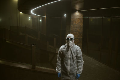 Man standing against illuminated wall