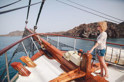 Woman sailing in aegean sea against sky