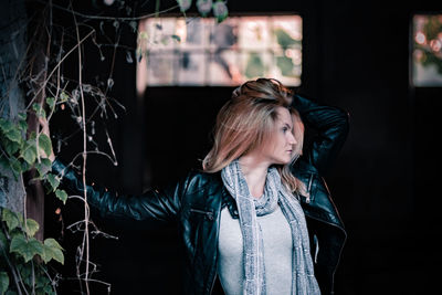 Young woman looking away while standing outdoors