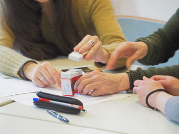 Midsection of businesswomen playing with boxes on table