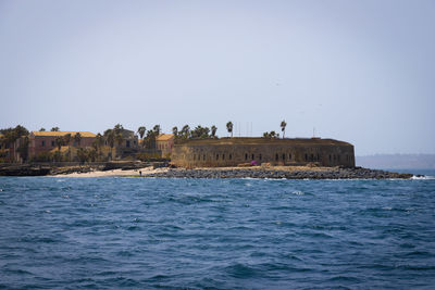 Scenic view of sea by buildings against clear sky