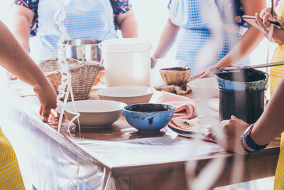 Midsection of women preparing food at table