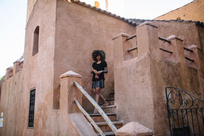 Low angle view of woman standing on staircase of building