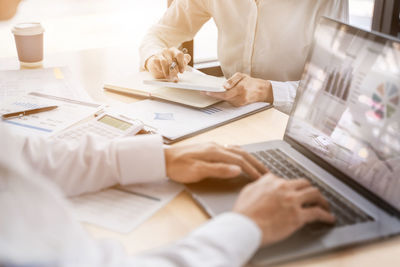 Midsection of man using laptop on table