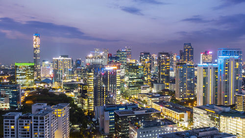 Illuminated buildings in city against sky at night