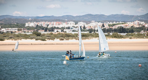 High angle view of sailboat in sea against mountains