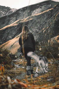Girl walks the dog in the mountains in autumn