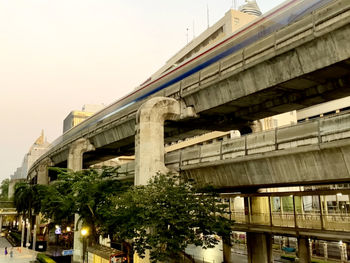 Low angle view of bridge and buildings against sky