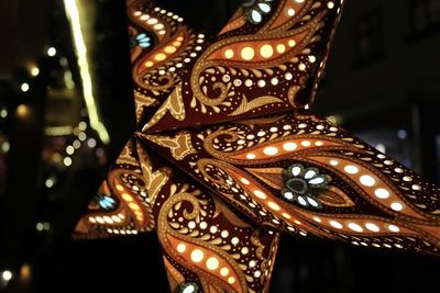 Low angle view of illuminated lighting equipment at night