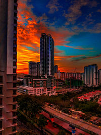Modern buildings in city against sky during sunset