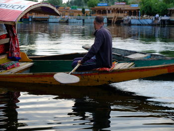 Reflection of man on boat in lake