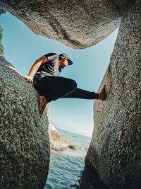 Low section of man jumping in sea