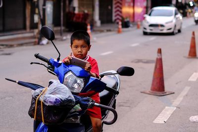 Boy riding bicycle on street in city