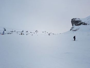 Birds flying over snowcapped mountains against sky