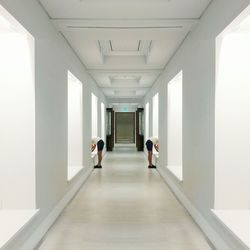 Rear view of people walking in corridor
