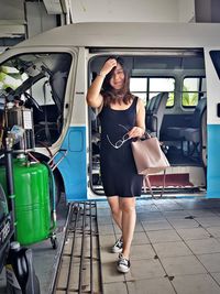 Full length portrait of young woman standing on bus