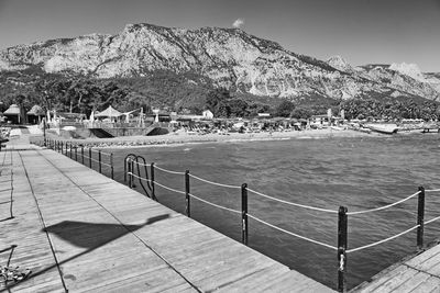 Scenic view of sea by mountains against sky