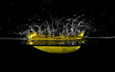 Close-up of yellow splashing water at night