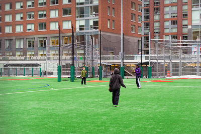Full length of man playing soccer in city