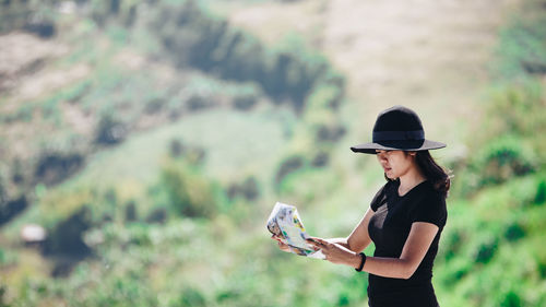 Woman reading map on mountain