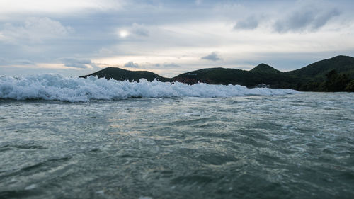 Scenic view of sea and mountains against sky