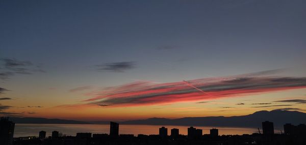 Silhouette buildings against sky during sunset