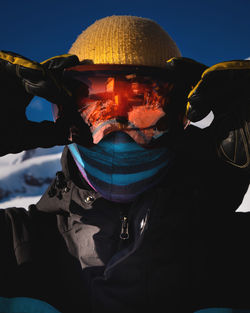 Close-up of men's ski goggles with reflection of snowy mountains. man against the blue sky. winter