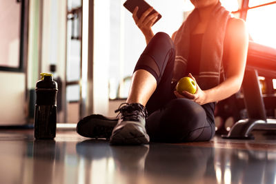 Low section of woman sitting in gym