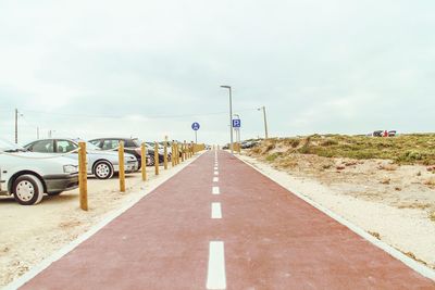 Empty road against cloudy sky