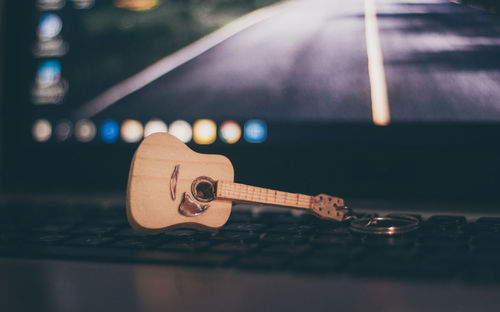 Close-up of figurine guitar on laptop
