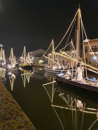 Sailboats moored at harbor