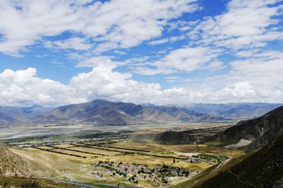 Scenic view of field and mountains against sky