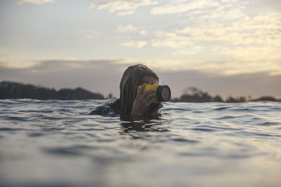 Young man holding underwater camera in the ocean