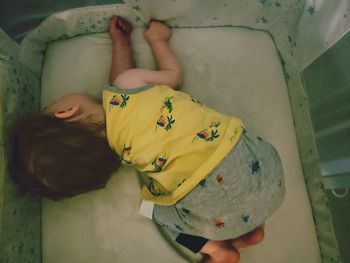 High angle view of boy sleeping on bed at home