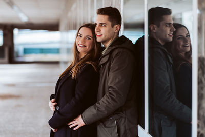 Side view of young couple standing in corridor
