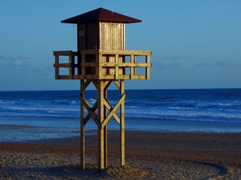 Lifeguard hut on beach against sky