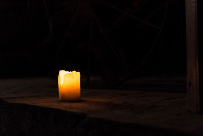 Close-up of illuminated candle on table