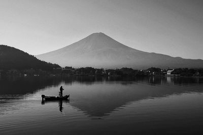 View of person fishing on lake against sky