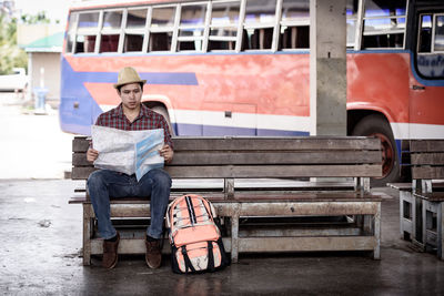 Full length of man sitting on seat