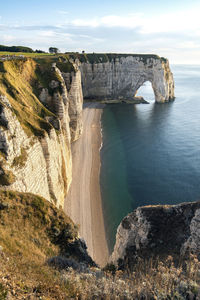 Rock formations by sea against sky