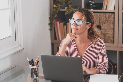 Woman using mobile phone at home