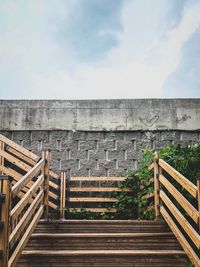 Staircase of building against cloudy sky